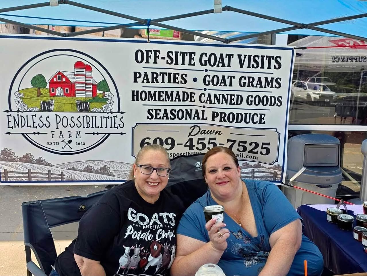 Two smiling people at the Endless Possibilities Farm stand with homemade canned goods